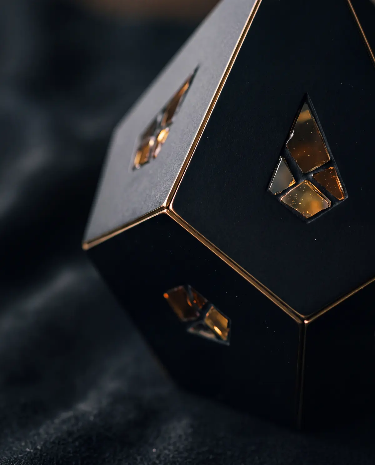 Illustration: macro of a matte black faceted object edged with a thin line of brass light