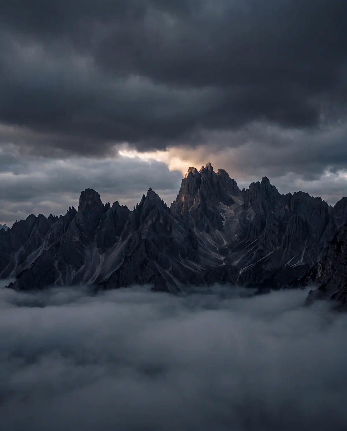 Illustration: a dark mountain ridge above a sea of cloud with one thread of warm light on the summit